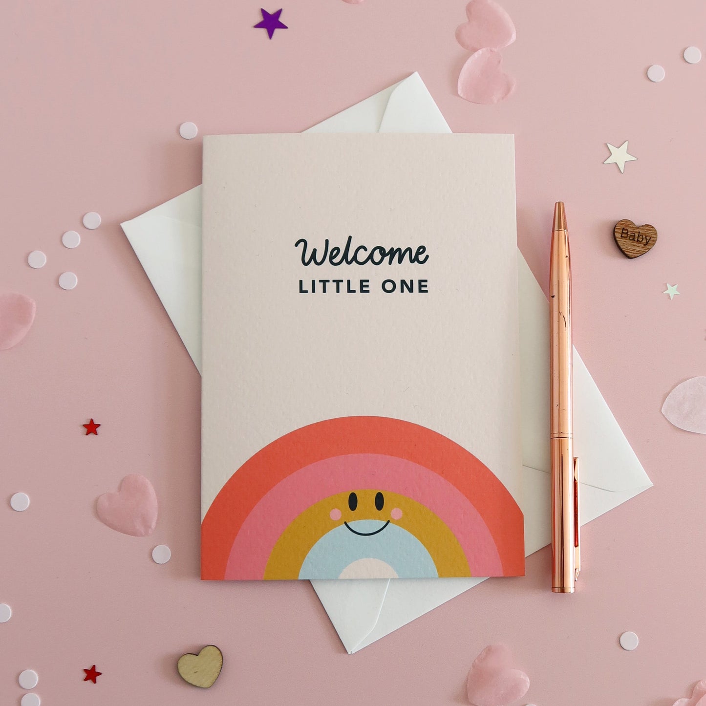Greeting card with rainbow design and 'Welcome Little One' text on a pink background with confetti.